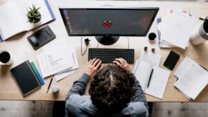 A realistic image of a Raspberry Pi setup on a desk, surrounded by books and certification materials. A person is studying intently.