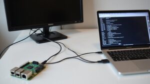 A realistic image of a Raspberry Pi 4 connected to power and ethernet on a clean desk, without monitor, keyboard or mouse. Wires neatly organized, SSH terminal open on laptop nearby showing command line connection to the Pi.
